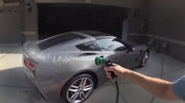 Washing a C7 Corvette with a hose near the garage