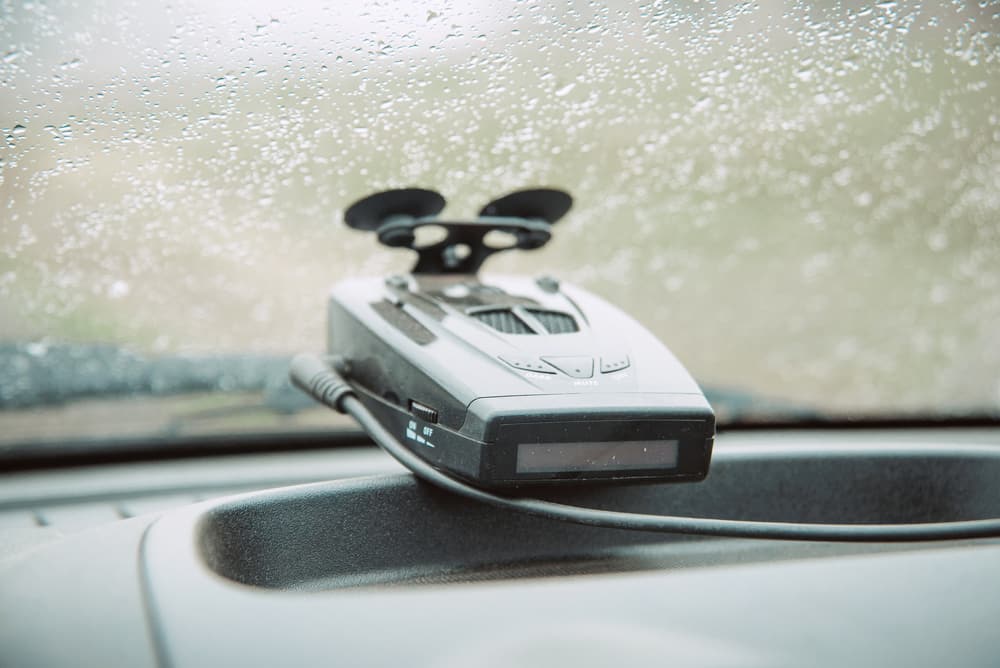 Black radar detector attached to the windshield